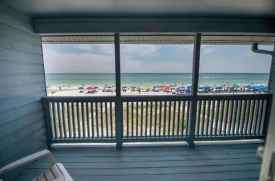 a screened in porch with a view of the beach at Seagull Villas #7 by Emerald Coast Retreats in Panama City Beach