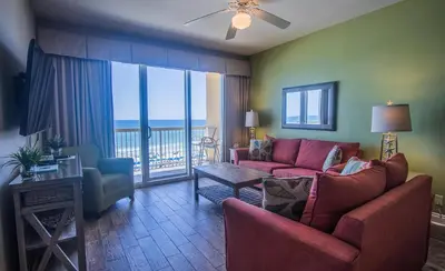 a living room with a couch and a table at Calypso 2-404 by Emerald Coast Retreats in Panama City Beach