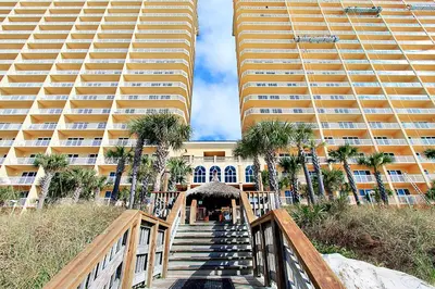 a staircase leading to a building with two tall buildings at Calypso 2-404 by Emerald Coast Retreats in Panama City Beach