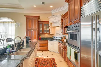 a kitchen with wooden cabinets and a stainless steel refrigerator at Like No Other in the Panhandle of Florida in Seacrest