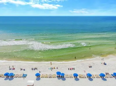 a beach with umbrellas and chairs and the ocean at Sandy Feet Retreat 3 bed 3 bath in Panama City Beach