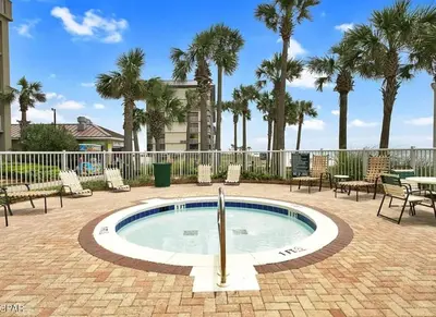 a small pool with a fountain in a patio with palm trees at Sandy Feet Retreat 3 bed 3 bath in Panama City Beach