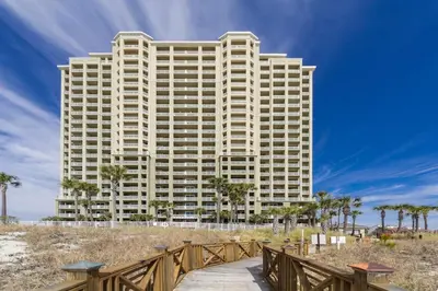 a tall building with a walkway in front of a beach at Blue Haven Escape, 2 Bed 2 Bath in Panama City Beach