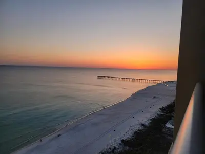 a view of a beach at sunset with a pier at Blue Haven Escape, 2 Bed 2 Bath in Panama City Beach