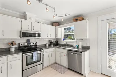 a kitchen with white cabinets and a stove top oven at Laguna Breeze! Dog-Friendly 4BR Beach Escape for 8 with Coastal Charm! in Panama City Beach