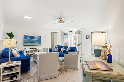 a living room with blue furniture and a blue couch at Laguna Breeze! Dog-Friendly 4BR Beach Escape for 8 with Coastal Charm! in Panama City Beach