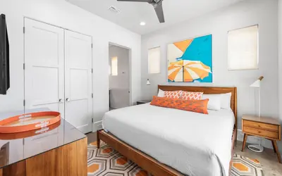 a bedroom with a bed and a desk with a table at Sealah in Rosemary Beach