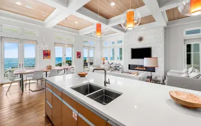 a kitchen with a sink and a living room at Sealah in Rosemary Beach