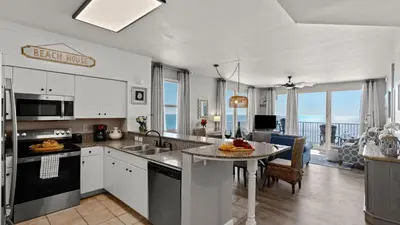 a kitchen with a table and a dining room at Emerald Horizon by AvantStay Beachfront Condo Resort Pool Gulf Balcony Views Near Pier Park Dining in Panama City Beach