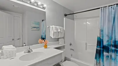 a white bathroom with a sink and a shower at Emerald Horizon by AvantStay Beachfront Condo Resort Pool Gulf Balcony Views Near Pier Park Dining in Panama City Beach