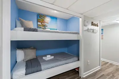 two bunk beds in a room with blue walls at Moondrifter 205 in Panama City Beach