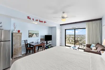 a bedroom with a bed and a table and a couch at Origin 0933 - Studio King - Sunrise Gulf Views in Panama City Beach