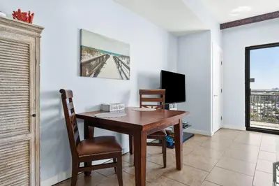 a dining room with a table and chairs and a television at Origin 0933 - Studio King - Sunrise Gulf Views in Panama City Beach