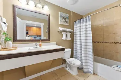 a bathroom with a sink and a toilet and a mirror at Origin 0933 - Studio King - Sunrise Gulf Views in Panama City Beach