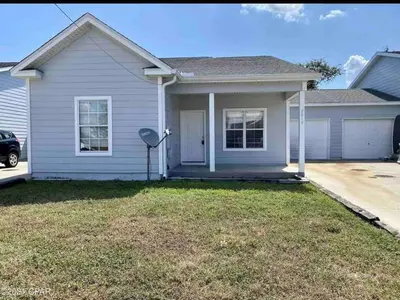 a white house with a lawn in front of it at Beach Days, Nightlife Nights, East End of PCB in Panama City Beach