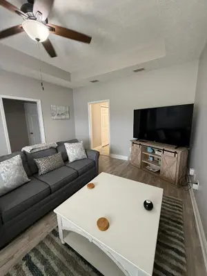 a living room with a couch and a flat screen tv at Beach Days, Nightlife Nights, East End of PCB in Panama City Beach