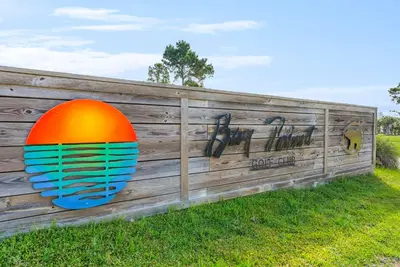 a wooden fence with a large orange ball on it at Pet Friendly Beach House - Sunset by the Sea in Panama City Beach