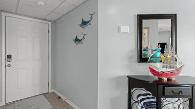 a hallway with a mirror and a table at Emerald Lagoon by AvantStay Bright Condo Pool Pier Tennis Access Walk to Beach Dining in Panama City Beach