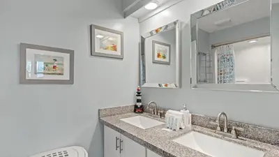 a bathroom with two sinks and a mirror at Emerald Lagoon by AvantStay Bright Condo Pool Pier Tennis Access Walk to Beach Dining in Panama City Beach