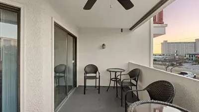 a balcony with chairs and a table on a building at Emerald Lagoon by AvantStay Bright Condo Pool Pier Tennis Access Walk to Beach Dining in Panama City Beach