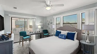 a bedroom with a bed and a desk with a computer at Emerald Lagoon by AvantStay Bright Condo Pool Pier Tennis Access Walk to Beach Dining in Panama City Beach
