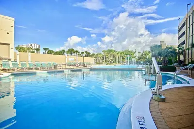 a large swimming pool with blue water and chairs at Bluewater Condo-Stunning Emerald Beach Resort Gulf-Front Condo with Spacious Balcony in Panama City Beach