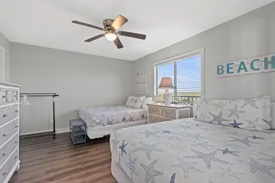 a bedroom with two beds and a ceiling fan at Commodore 0403 in Panama City Beach