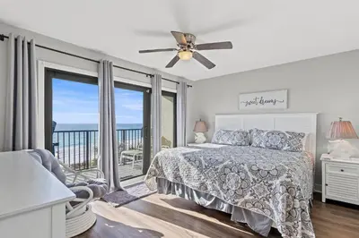 a bedroom with a bed and a balcony at Commodore 0403 in Panama City Beach