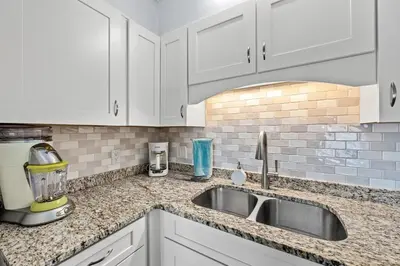 a kitchen with white cabinets and a sink at The Summit - Family Friendly Vacation! in Panama City Beach