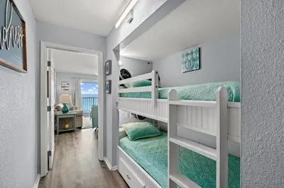 a bedroom with two bunk beds and a doorway at The Summit - Family Friendly Vacation! in Panama City Beach