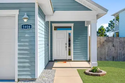 a blue house with a sign on the door at Sunset Nirvana in Panama City Beach