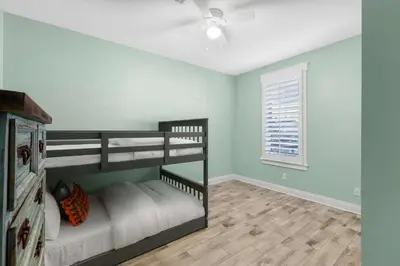 a bedroom with two bunk beds and a ceiling fan at Sunset Nirvana in Panama City Beach