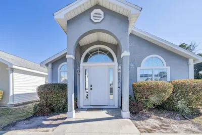 a blue house with a white door at Jade Shell in Panama City Beach