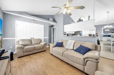 a living room with two couches and a ceiling fan at Jade Shell in Panama City Beach