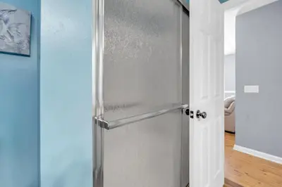 a stainless steel refrigerator in a kitchen next to a door at Jade Shell in Panama City Beach