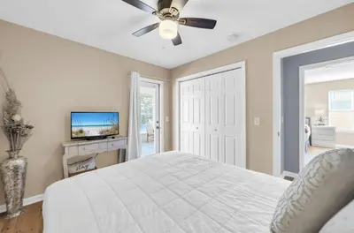 a bedroom with a bed and a ceiling fan at Jade Shell in Panama City Beach