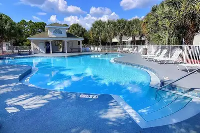 a large swimming pool with chairs around it at Jade Shell in Panama City Beach