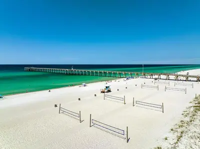 a beach with a pier and the ocean at Pet Friendly Beach House - Beachside Sunrise in Panama City Beach