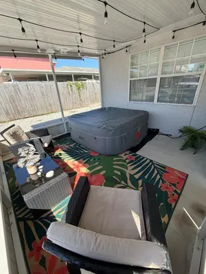 a patio with a bed and chairs on a rug at Lux min to Beach and Hospital with Hot Tub in Panama City