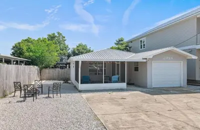 a house with a garage and a table and chairs at Lux min to Beach and Hospital with Hot Tub in Panama City