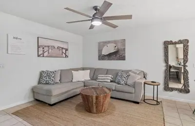 a living room with a couch and a ceiling fan at Lux min to Beach and Hospital with Hot Tub in Panama City