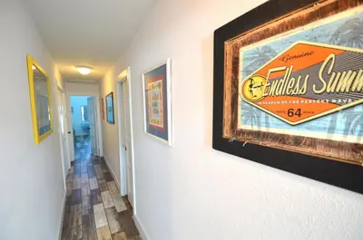 a hallway with paintings on the walls of a house at Emerald Seascape! Gulf front! Dog friendly! in Panama City Beach