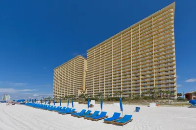 a row of chairs on the beach in front of a hotel at It’s Sea-esta Time! Sleep, Sun, & Sea on the 9th Floor! Sleeps 6! Beachfront! in Panama City Beach