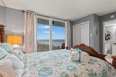 a bedroom with a bed with a view of the ocean at Buoy Oh Buoy! Sun, Sand, and Smiles Await! Sleeps 8! in Panama City Beach
