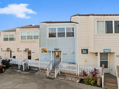 a house with a white fence in front of it at GO-JO Getaway! Coastal Comfort, 2BR Beachfront Townhouse, Sleeps 6 in Panama City Beach