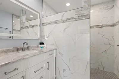 a white bathroom with a shower and a sink at GO-JO Getaway! Coastal Comfort, 2BR Beachfront Townhouse, Sleeps 6 in Panama City Beach