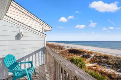 a blue chair sitting on a balcony overlooking the beach at GO-JO Getaway! Coastal Comfort, 2BR Beachfront Townhouse, Sleeps 6 in Panama City Beach