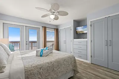 a bedroom with a bed with a ceiling fan at GO-JO Getaway! Coastal Comfort, 2BR Beachfront Townhouse, Sleeps 6 in Panama City Beach