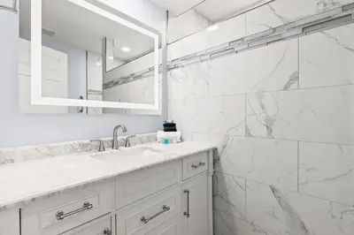a white bathroom with a sink and a mirror at GO-JO Getaway! Coastal Comfort, 2BR Beachfront Townhouse, Sleeps 6 in Panama City Beach