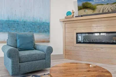 a living room with a chair and a fireplace at Keep Calm & Pool On at Peaceful Easy Feeling! Sleeps 20! in Panama City Beach